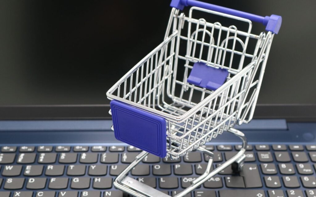 Mini carrinho de compras sobre um notebook