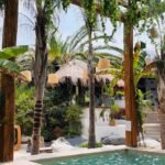 Piscina com pérgola e plantas em uma hospedagem