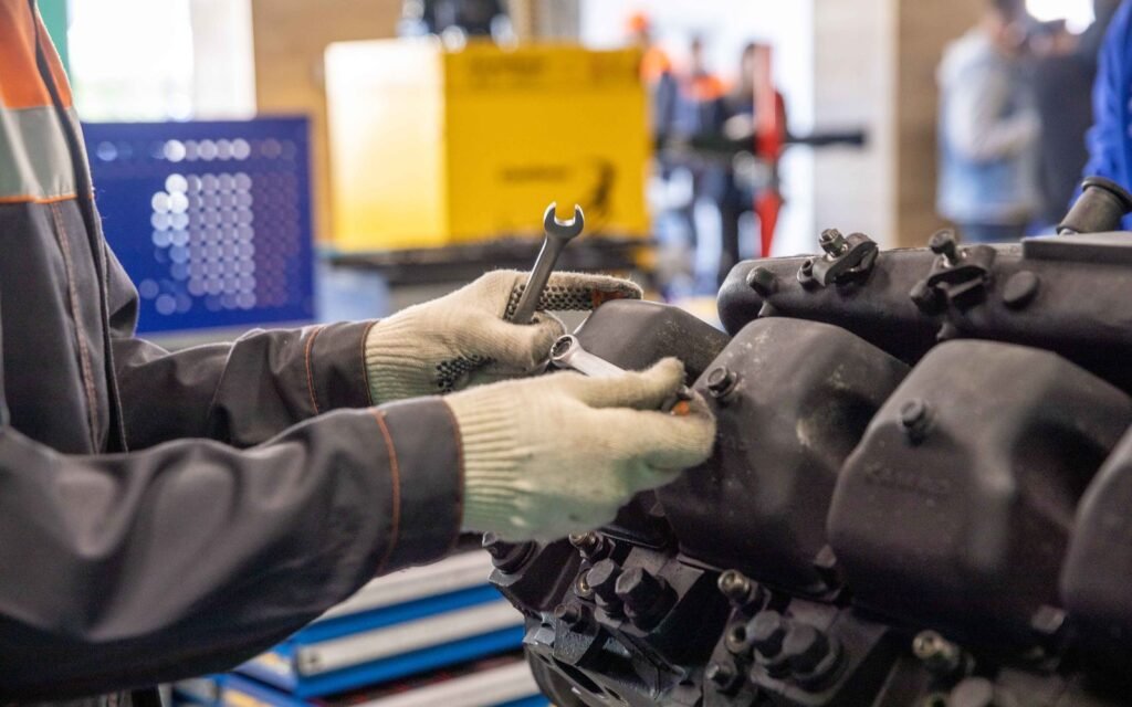 Mecânico trabalhando em um motor dentro de uma oficina