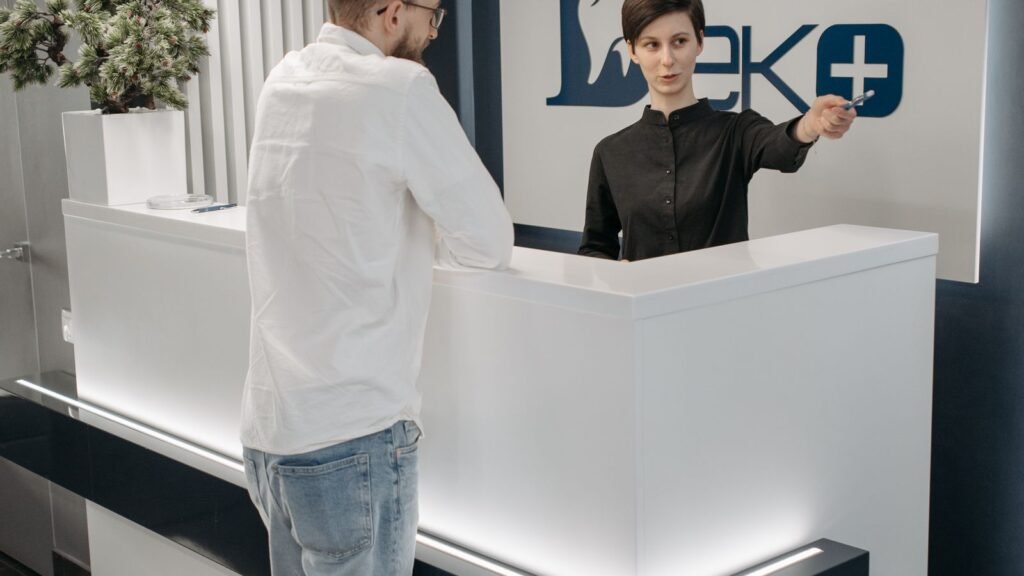 Recepcionista de clínica odontológica atendendo paciente