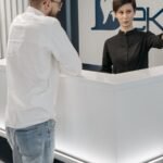 Recepcionista de clínica odontológica atendendo paciente